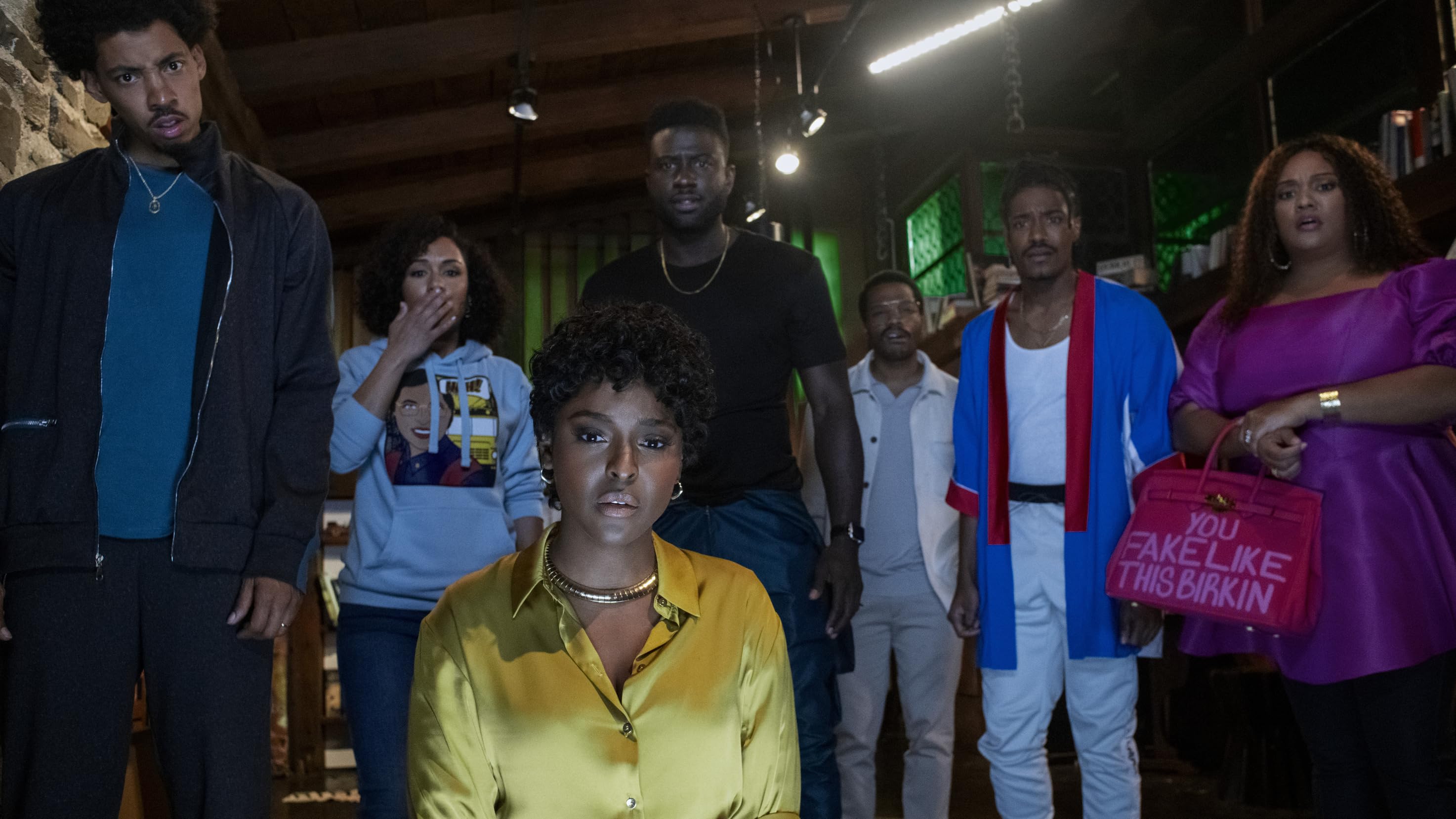 the blackening: the cast stares at the camera, the light of a television lighting their faces
