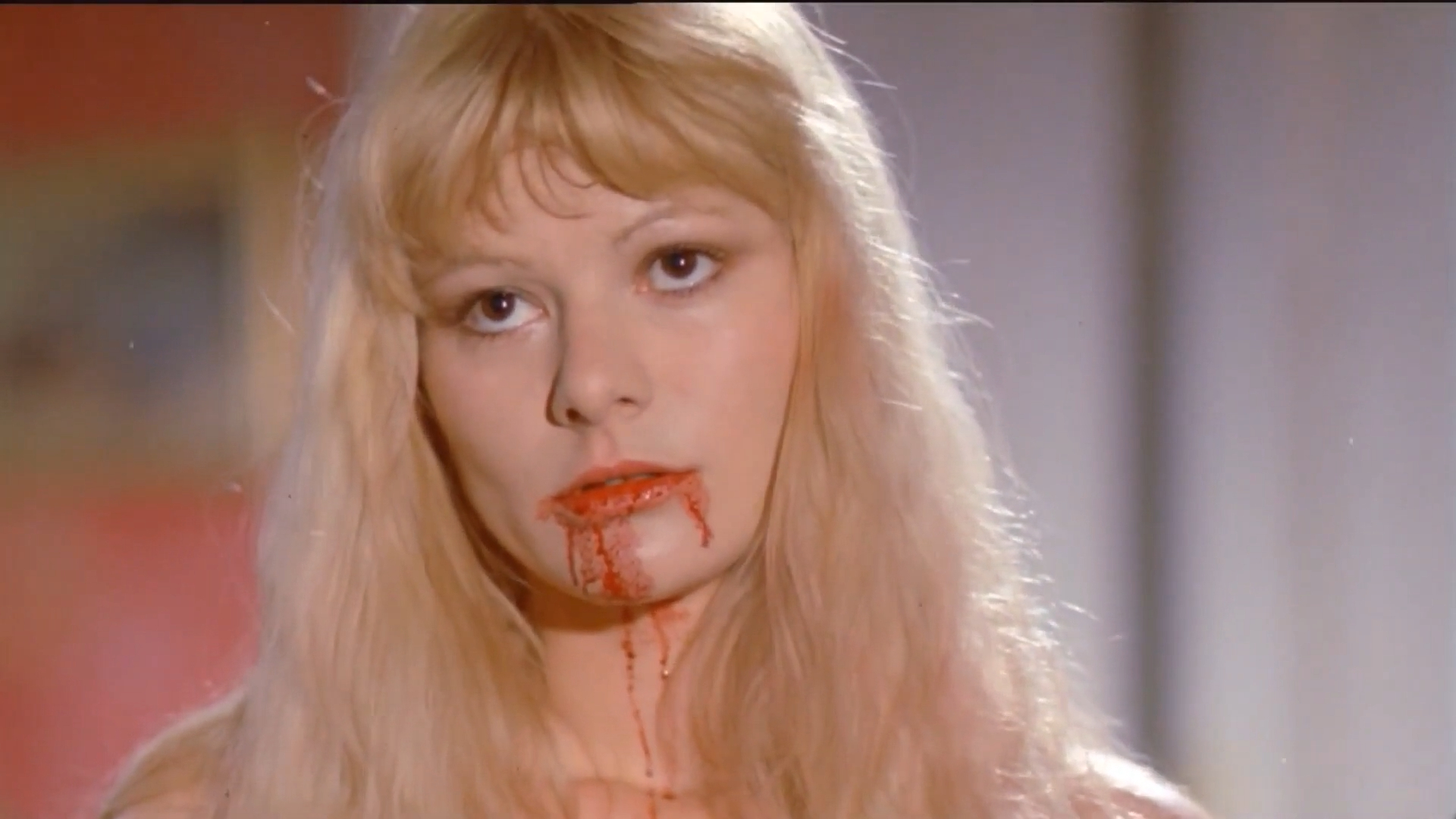 the living dead girl - a close-up of a woman whose mouth has blood on it.