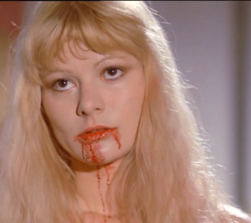 the living dead girl - a close-up of a woman whose mouth has blood on it.
